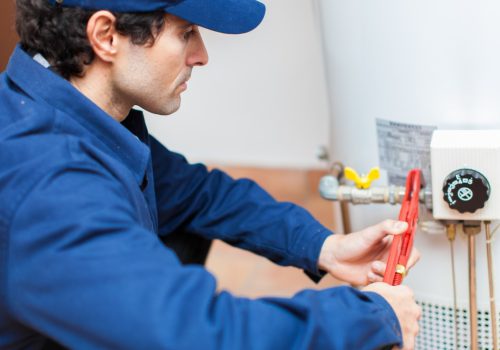 A contractor repairing a water heater while providing Residential Plumbing services in Peoria IL