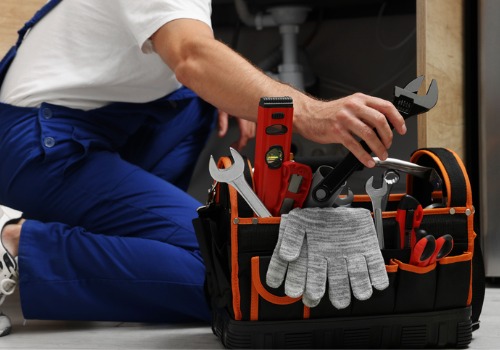 A worker pulling tools out of his bag, getting ready to work on residential plumbing in Bloomington IL