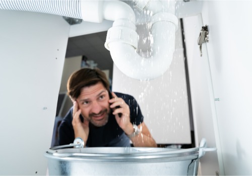 A man is seen looking at a leaking pipe. TCI Plumbing are Plumbers in East Peoria IL