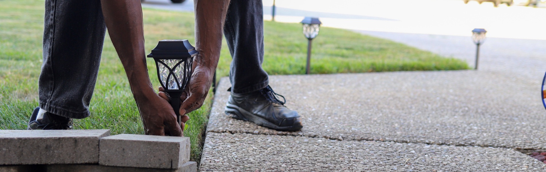 A man installs a solar landscaping light in a lawn as part of the offerings TCI Companies provides for its Galesburg utility services.
