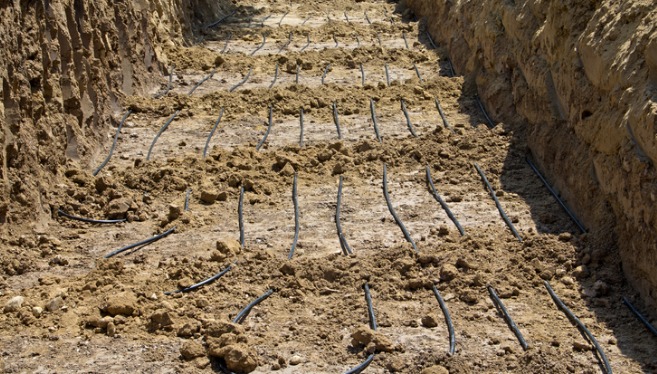 A trench is filled with tubing used for the installation of a geothermal residential heating and cooling system from TCI Companies.