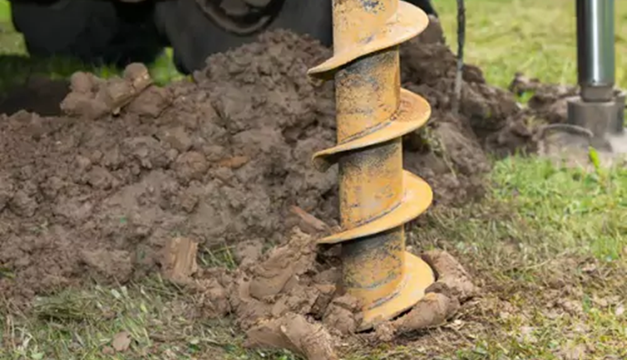 A drill going into the ground to start digging a well, part of TCI Companies' plumbing & utility services for Central Illinois