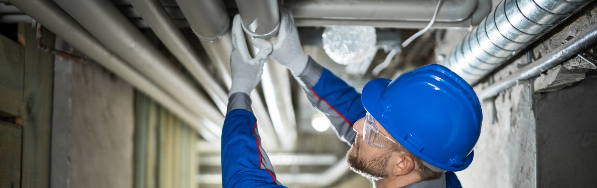 A member of TCI Plumbing inspects water pipes during a commercial plumbing project.