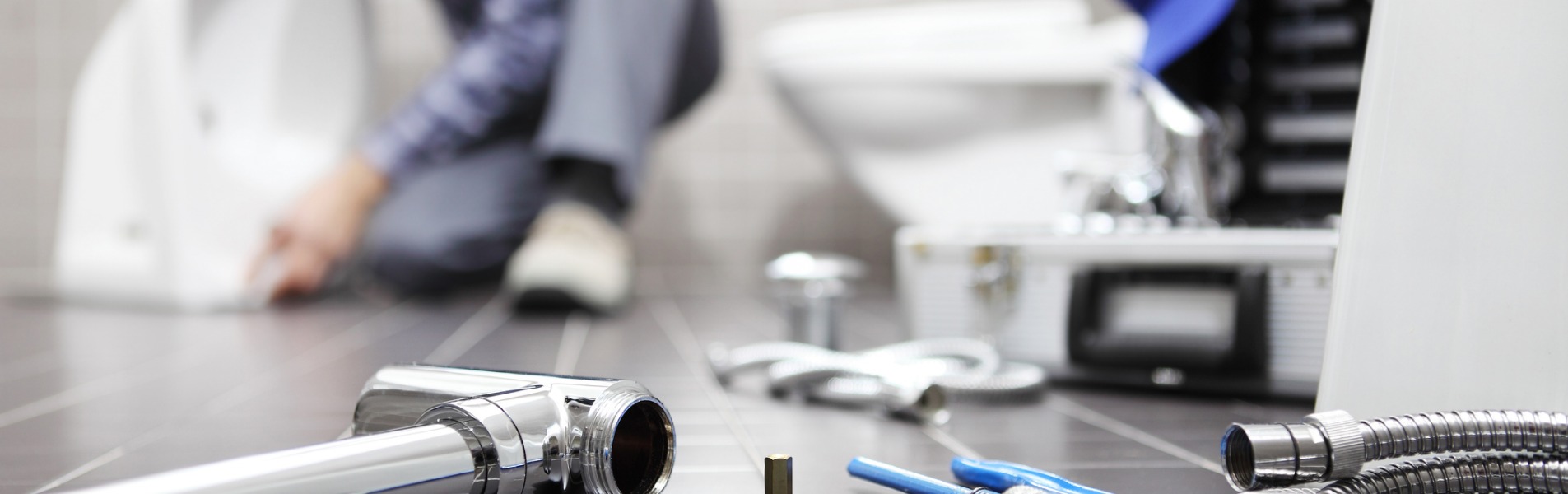 A plumber works in a bathroom to install a new toilet as part of the services TCI Companies offers for its Galesburg utility services.