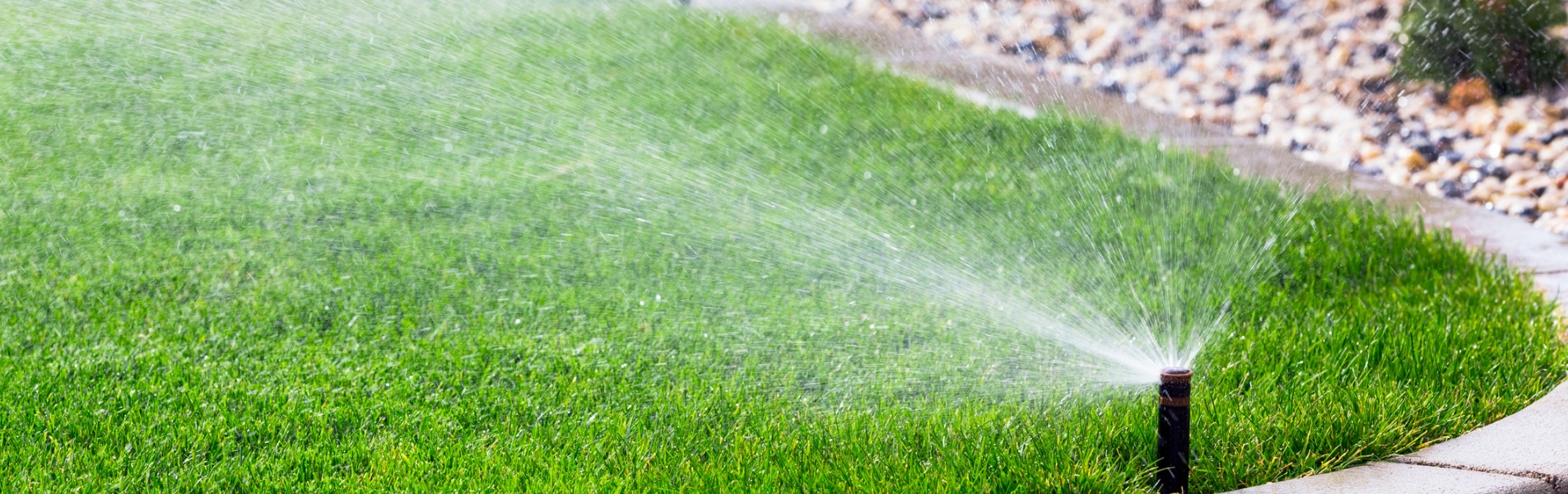 Automatic sprinklers, installed by TCI Companies’ plumbing & utility services team, water a lawn