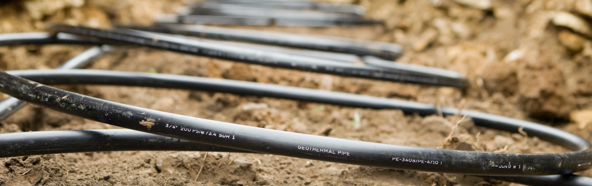 Workers from TCI Companies, a Decatur utility services company, lay beothermal coils in an underground trench.